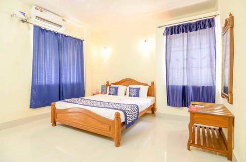 科尔瓦Williams Beach Retreat的一间卧室配有床和蓝色窗帘的窗户