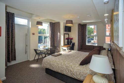 诺里奇Riverside Hotel的卧室配有一张床和一张桌子及椅子