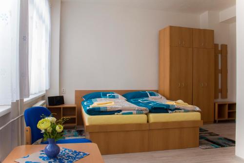 科希策ŠD Urbánkova 2的一间卧室配有一张床和一个木制橱柜