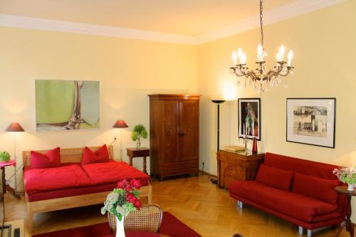德累斯顿Elbvilla Dresden的客厅配有2张红色沙发和吊灯。