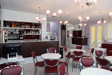 托雷拉皮罗Hotel Perla Dello Ionio的一间带桌椅的餐厅和一间酒吧