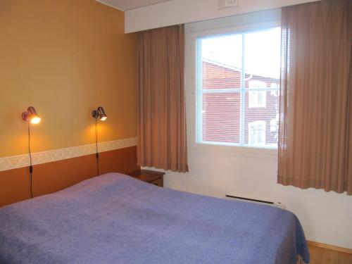 萨利色尔卡Lapin Kutsu Holiday Homes的一间卧室设有蓝色的床和窗户。