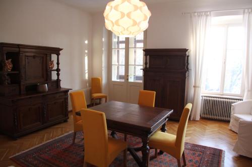 沃尔特湖畔韦尔登Villa Adrienne的一间带木桌和黄色椅子的用餐室
