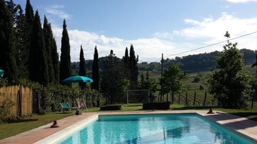 圣吉米纳诺农庄卡萨酒店的一座树木繁茂的庭院内的游泳池