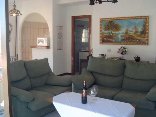 阿尔姆尼卡Casa Mariana的客厅配有沙发和桌子上的一瓶