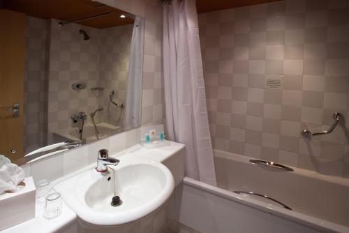 博尔顿大不列颠博尔顿酒店的浴室配有水槽、淋浴和浴缸。