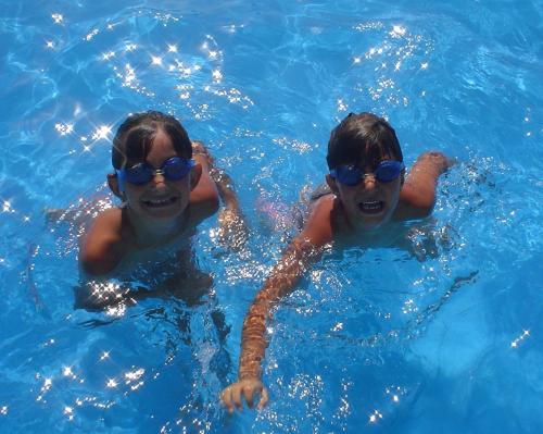 比比翁米拉马雷酒店的两个穿着太阳镜的男孩在游泳池里