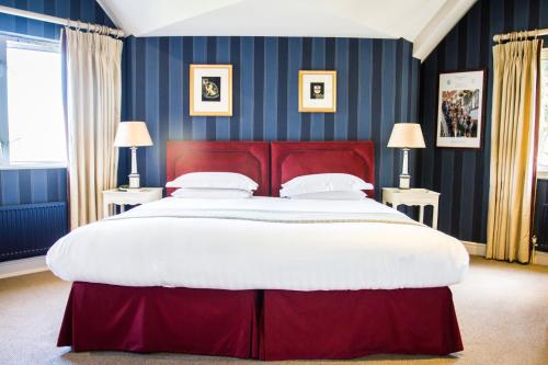 亨利昂泰晤士Leander Club的卧室内的一张带红色床头板的大床