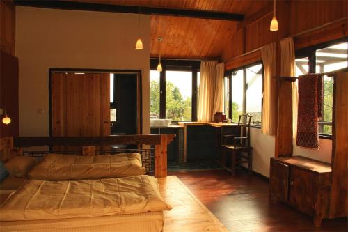 丽江丽江白沙自由岁月设计旅店的一间带两张床的卧室和一间带窗户的厨房
