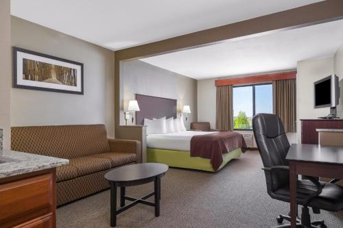 罗切斯特AmericInn by Wyndham Rochester的酒店客房,配有床和沙发