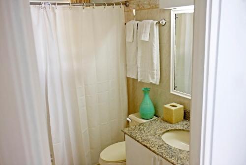 基督教堂市ZenBreak Silver Sands Villa 1的浴室设有白色的淋浴帘和水槽