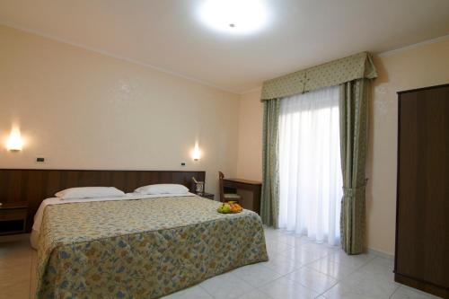 圣乔瓦尼·罗通多Hotel Primula的酒店客房设有床和窗户。
