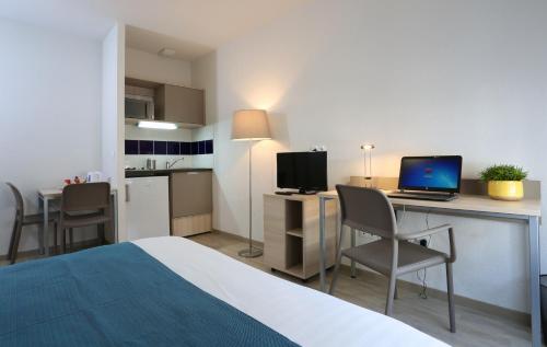 南希南锡公寓式酒店的酒店客房配有一张床、一张书桌和一台笔记本电脑