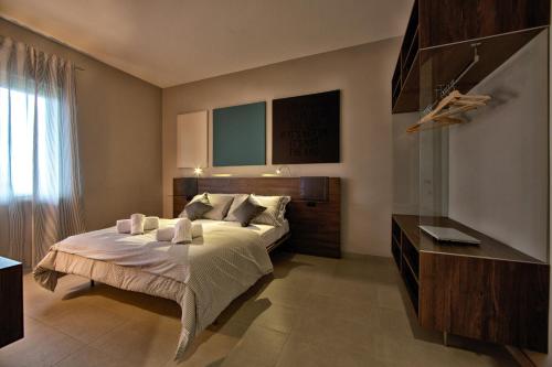 PatricaLepini Suites的一间卧室配有带梳妆台和窗户的床。