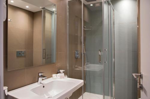 托雷德尔格雷科玛拉德酒店的一间带水槽和玻璃淋浴的浴室