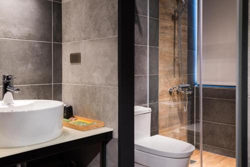 嘉义市日出行旅的浴室配有卫生间、盥洗盆和淋浴。