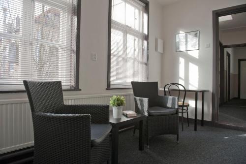埃因霍温天鹅经济酒店的配有椅子和桌子的房间,窗户