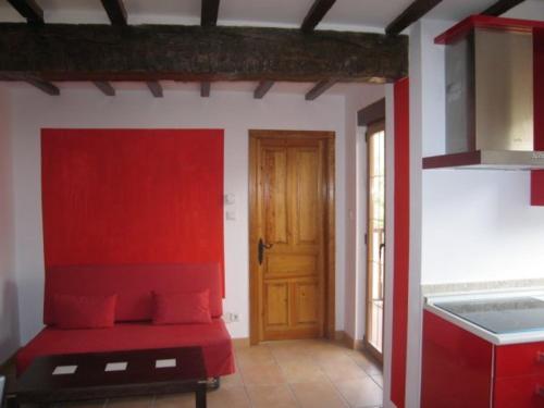 蓬特维耶斯戈Apartamentos Puente Viesgo Anjana的一间设有红色床和门的房间