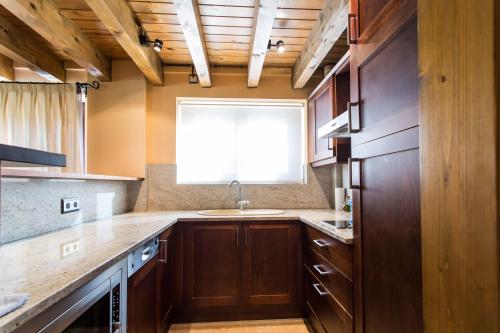 拉莫利纳格兰瓦尔酒店的厨房配有木制橱柜、水槽和窗户。