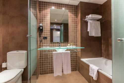 萨拉戈萨阿拉贡国王费尔南多二世水疗酒店的一间带水槽、浴缸和卫生间的浴室