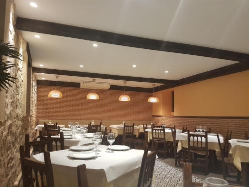 锡古恩萨麦松卡斯蒂利亚旅馆的用餐室配有桌椅和白色桌布
