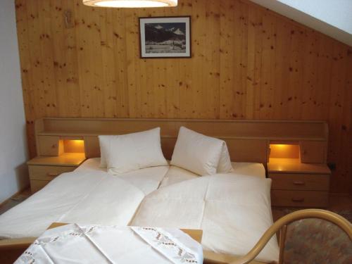 大格洛克纳山麓卡尔斯Lucknerhof的一间卧室配有白色床和两盏灯