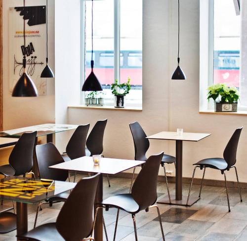 利勒哈默尔Lillehammer Stasjonen Hotel的餐厅设有桌椅和窗户。