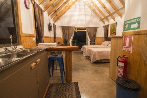 安加罗阿Pacific Bungalows的一个带水槽的厨房和一张位于客房内的床