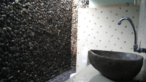 Labuhan Pandan彭杜克斯欧拉假日公园的一间带石质水槽和墙壁的浴室