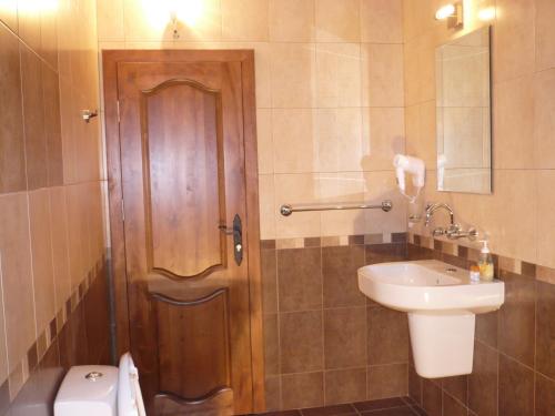 大特尔诺沃埃森奈维西酒店的一间带木门和水槽的浴室