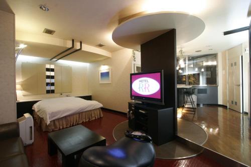 四日市RR酒店（仅限成人）的一间带电视和床的客厅
