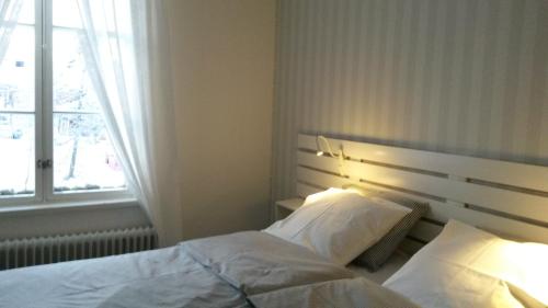 OutokumpuKyykerin Kartano的一间卧室配有一张带白色床单的床和一扇窗户。
