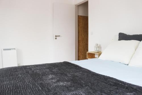 辛特拉辛特拉二人角落公寓的卧室配有一张带黑色毯子的白色床