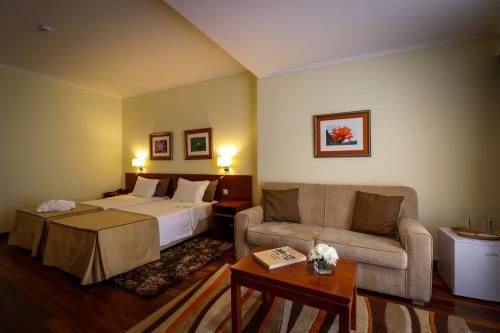 蓬塔德尔加达卡摩斯酒店的酒店客房,配有床和沙发