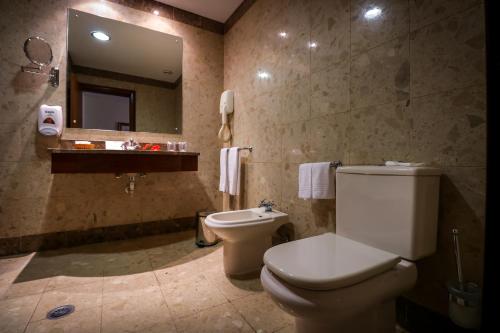 蓬塔德尔加达卡摩斯酒店的一间带卫生间、水槽和镜子的浴室