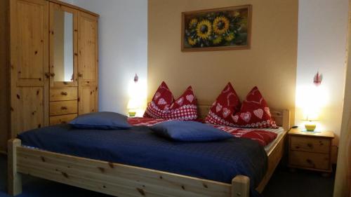 因斯布鲁克安格莉卡之家 - 住宿加早餐旅馆 - 因斯布鲁克/伊格尔斯的一间卧室配有一张带红色和蓝色枕头的床