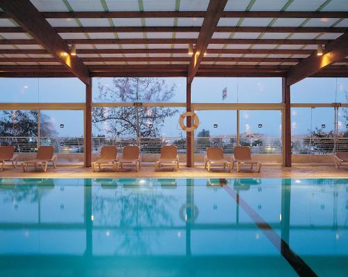 米茨佩·拉蒙Ramon Inn by Isrotel Collection的一个带椅子和大窗户的游泳池