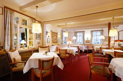 OberhundemHotel Gasthof Zu den Linden的餐厅配有桌椅和白色的桌布