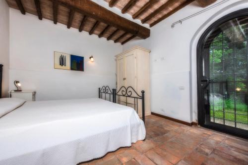圣吉米纳诺拉科琳娜德乐其农庄的一间卧室设有一张床和一个大窗户