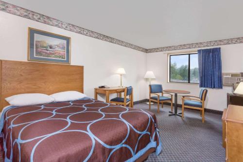 彼得斯堡Best Inn的酒店客房带一张床、一张桌子和椅子