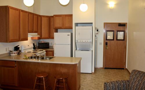 朱诺朱诺酒店的厨房配有白色家电和木制橱柜
