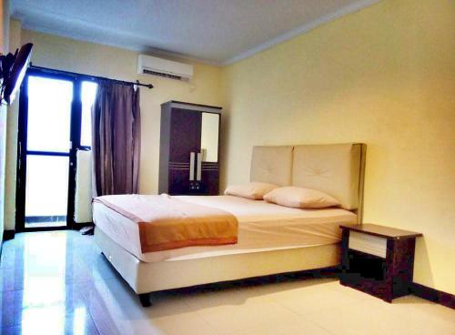 美娜多昆特酒店的一间卧室设有一张大床和一个窗户。