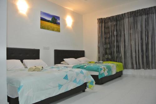 珍南海滩兰卡威波浪宾馆的一间卧室设有两张床和窗户。