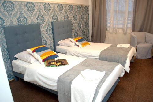 PleszewAcwador的酒店客房,配有两张床和椅子