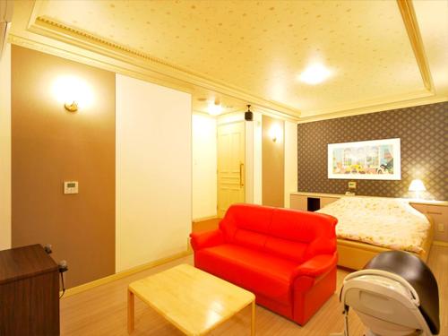 名古屋酒店.COM（仅限成人）的一间设有红色椅子和一张床的房间