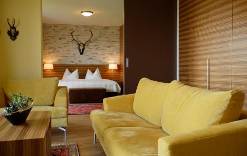 哈特贝格施雷纳斯伯格霍夫酒店的客厅配有沙发和1张床