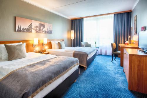 科隆科隆波恩机场莱昂纳多酒店的酒店客房设有两张床和电视。