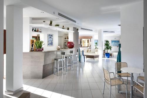 圣特奥多罗Terradimare Resort&Spa的厨房以及带酒吧和椅子的用餐室