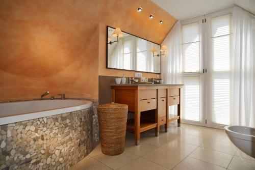 弗兰肯贝格迪桑尼弗兰肯贝格酒店的带浴缸、水槽和镜子的浴室