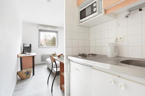 第戎内雷塞德-克洛斯莫洛公寓的白色的厨房配有水槽和微波炉